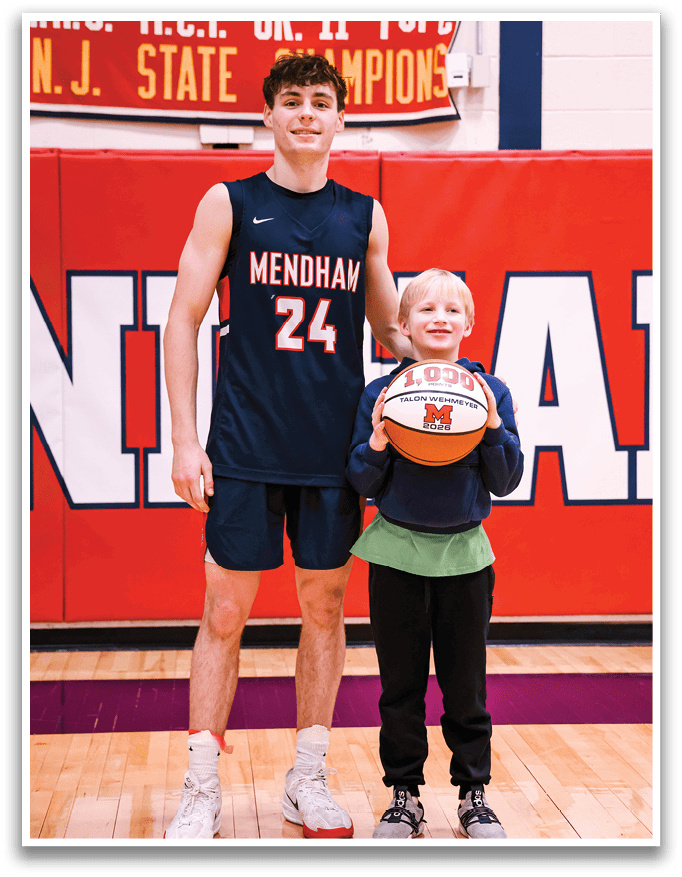 A young boy holds a basketball while standing next to a tall man, who is wearing a basketball jersey. AI generated content