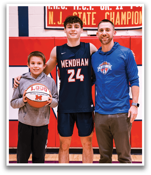 A man and a boy are standing in front of a sign that says “Girls Basketball" and "Boys Basketball." The man is holding a basketball. AI generated content