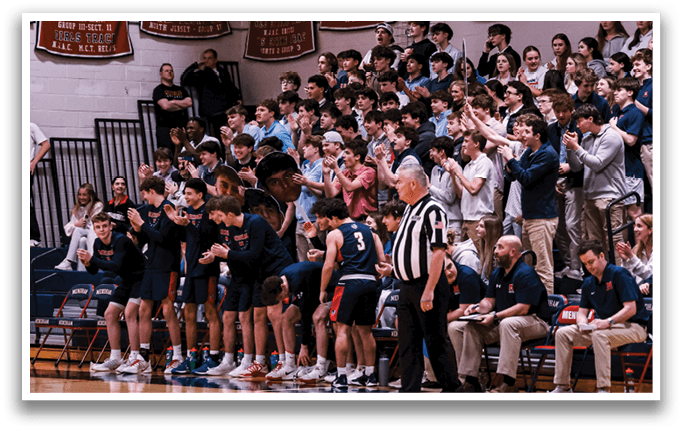 A group of people are gathered in a gym, with some sitting on chairs and others standing. A referee is present, and a clock is visible on the wall. The crowd is watching a basketball game, and the atmosphere is lively. AI generated content