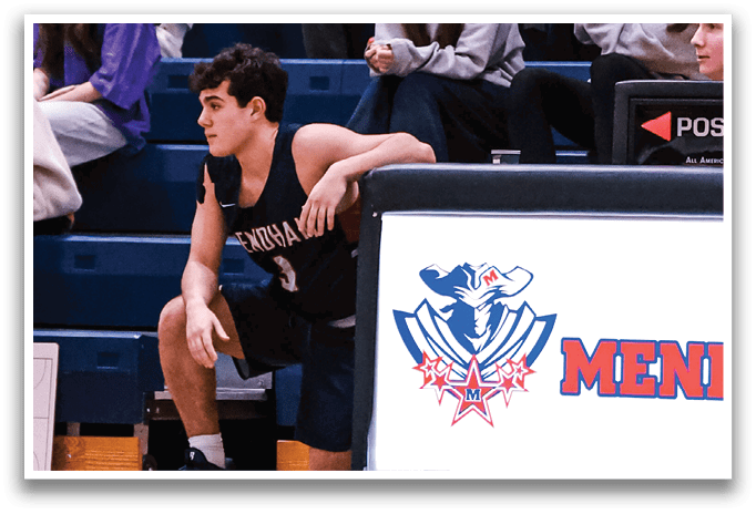 A man is sitting on the floor in front of a scoreboard, holding a basketball. AI generated content