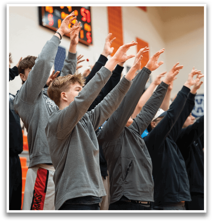 A group of people are standing in a line, with their hands raised in the air. Contenido generado con IA