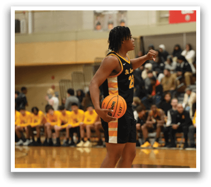 A basketball player stands on the court holding a basketball, surrounded by a crowd of spectators. Contenido generado con IA