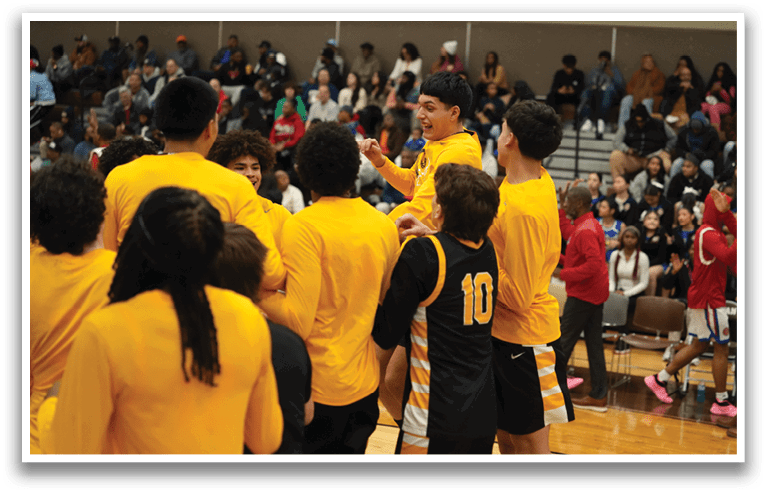 A group of young men in yellow and black uniforms are celebrating on a basketball court. Contenido generado con IA
