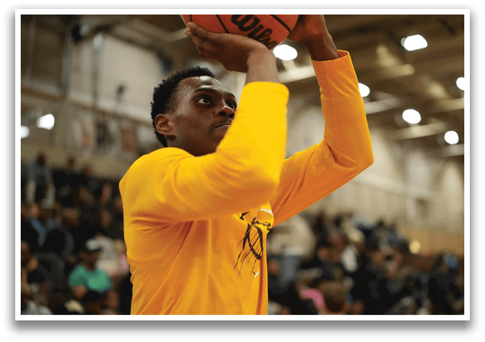 A man in a yellow shirt is holding a basketball. Contenido generado con IA