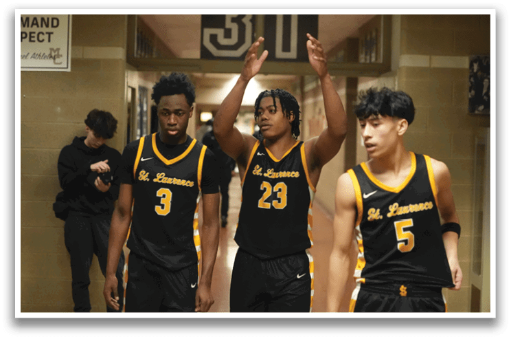 Three basketball players wearing black jerseys and shorts are standing in a hallway. Contenido generado con IA