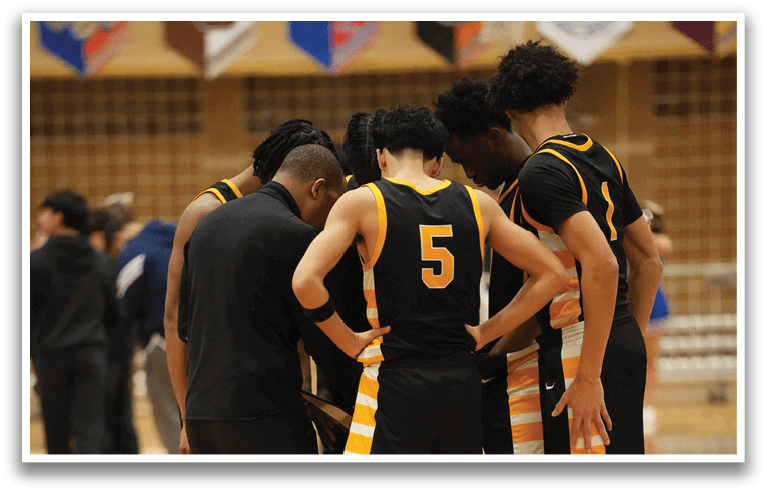 A group of people wearing black and yellow uniforms are standing on a basketball court. Contenido generado con IA
