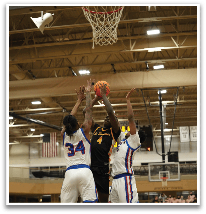 Basketball players are playing in a gym. One player is trying to block the shot of another player. Contenido generado con IA