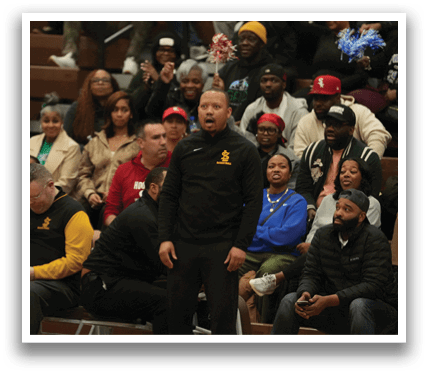 A group of people are sitting in the bleachers, watching a game. A man in a yellow shirt is talking on a cell phone. Contenido generado con IA
