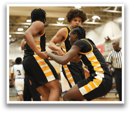 Three basketball players are hugging each other on the court, celebrating a victory. Contenido generado con IA