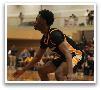 A man is playing basketball on a court, wearing a black and yellow jersey. Contenido generado con IA