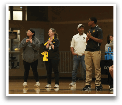A group of people are standing on a basketball court, watching a game. Contenido generado con IA
