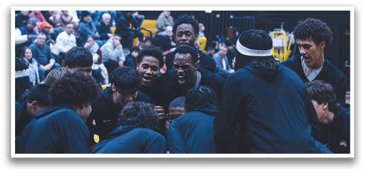 A group of young men wearing black and white uniforms are huddled together on a basketball court. AI generated content