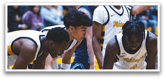 A group of men are on a basketball court, with one man lying on the ground and the others surrounding him. AI generated content