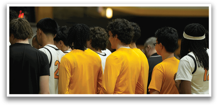 A group of young men wearing yellow shirts and black shorts stand together. AI generated content