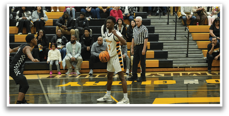 A basketball game is taking place in a crowded gymnasium. The players are actively engaged in the game, with one player holding a basketball in his hands. The audience is watching the game intently, with some sitting on benches and others standing. The atmosphere is lively and filled with excitement. AI generated content