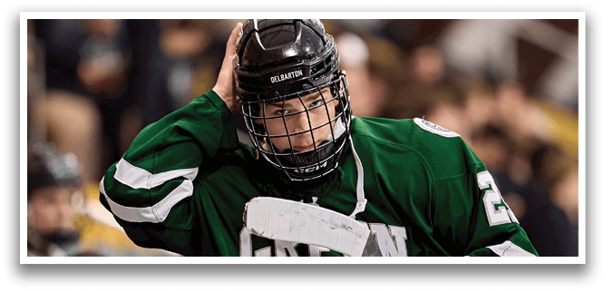 A hockey player with a green jersey and helmet is holding his head in his hands. AI generated content