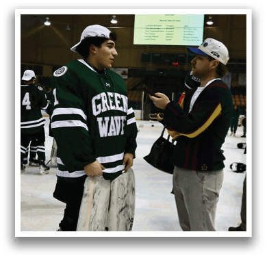 Two men are standing on ice, one wearing a green and white jersey and the other wearing a blue and yellow jacket. The man in the green and white jersey is holding a white and black goalie's pads. AI generated content