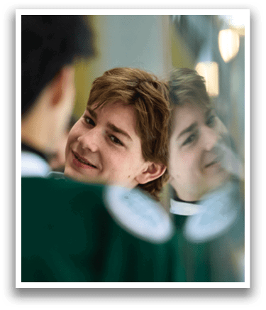 A young man is smiling at his reflection in a mirror. AI generated content
