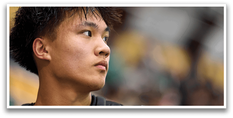 A man with black hair and a black shirt is looking off into the distance. AI generated content