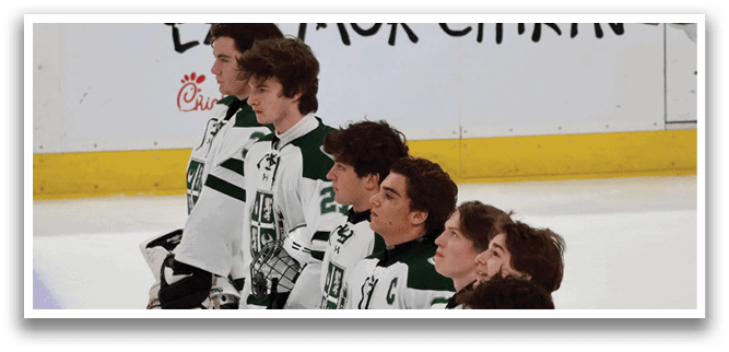A group of hockey players wearing white and green uniforms stand on the ice. AI generated content