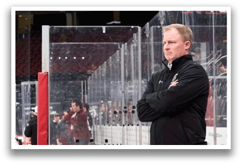 A man wearing a black jacket and a green shirt stands in front of a glass wall. AI generated content