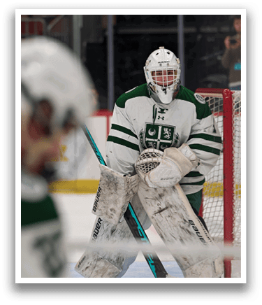 A hockey player wearing a white and green uniform is standing in front of a net. AI generated content