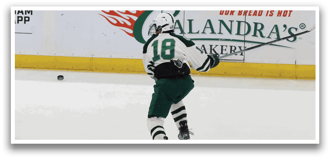 A hockey player wearing a green and white uniform is holding a hockey stick and skating on the ice. AI generated content