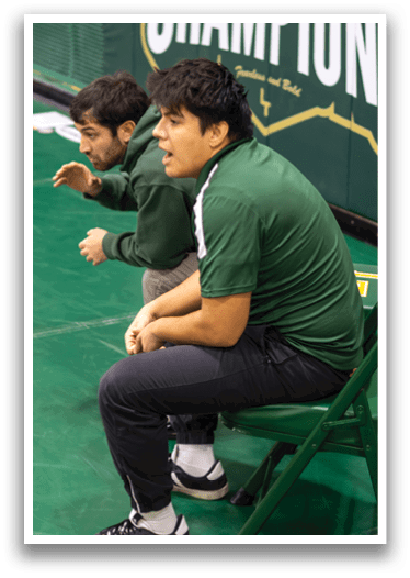 Two men are sitting on chairs, one of them is wearing a green shirt. AI generated content