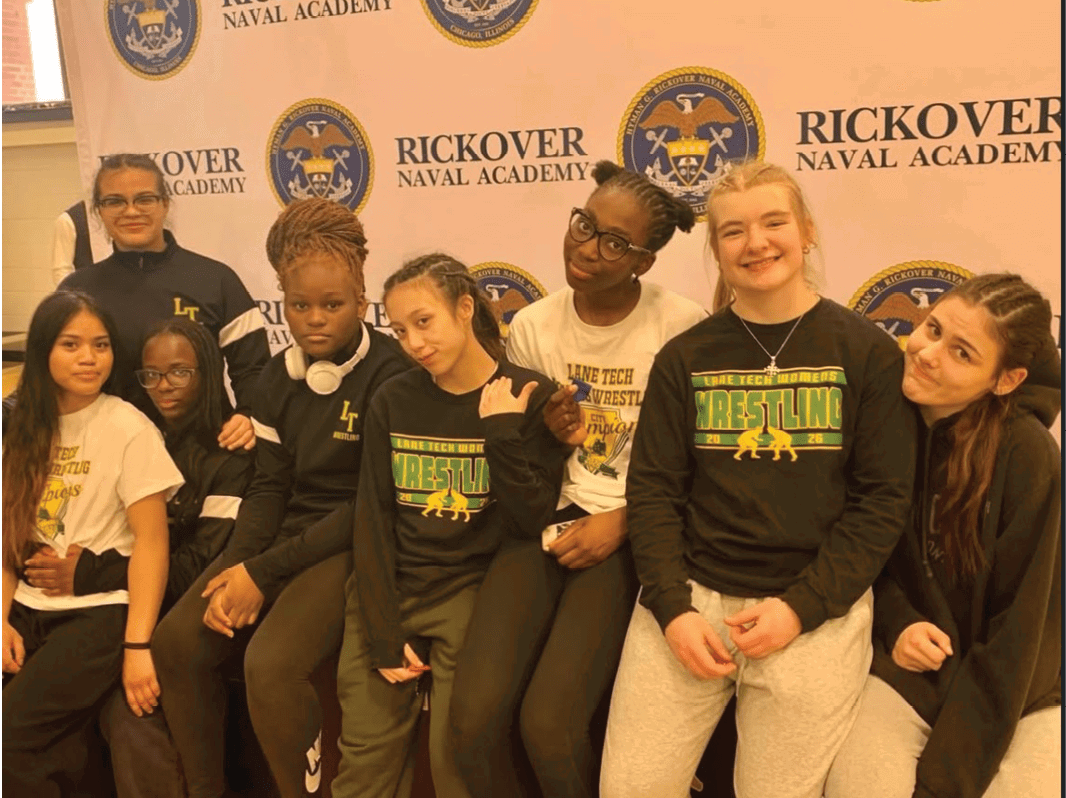 A group of young women pose for a photo in front of a banner. AI generated content