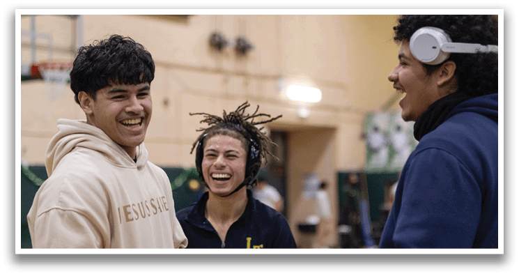 Three people are standing in a gym, smiling and laughing. One person is wearing a headset, and another is wearing a headband. They appear to be enjoying their time together. AI generated content