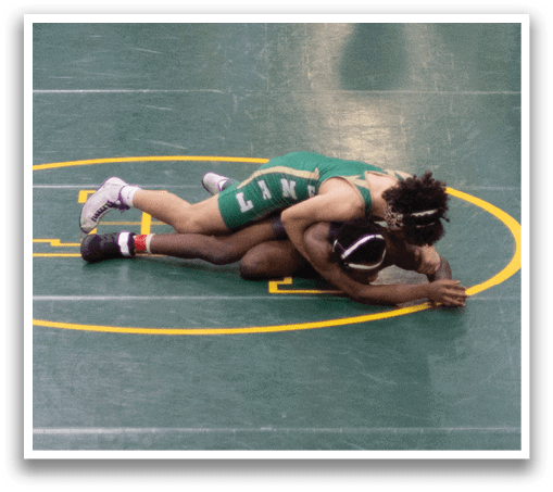 A wrestling match is taking place in a stadium, with a wrestler on the ground and another standing over him. The crowd is watching the match intently. AI generated content