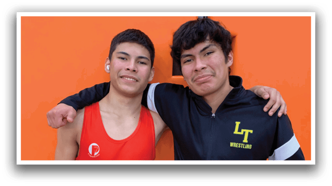 Two men wearing red and black shirts pose for a picture. AI generated content