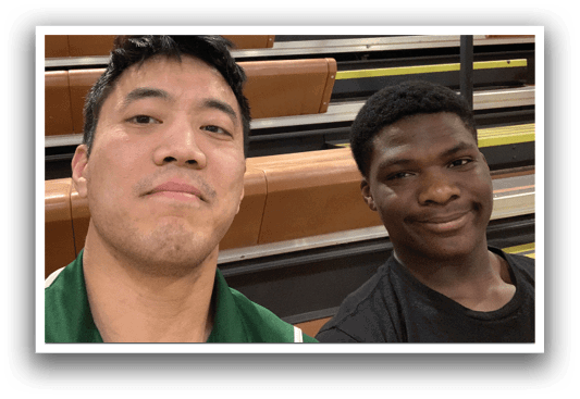 Two men are standing in a gym, one is smiling and the other is not. AI generated content