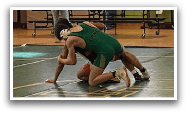 Two men are wrestling on a green mat in a gym. AI generated content