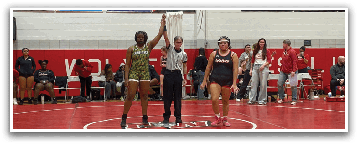 A wrestling match is taking place in a gym with a group of people watching. A man and a woman are standing in the center of the ring, holding up their hands. The woman is wearing a green shirt and the man is wearing a black shirt. There are several other people in the gym, some of them sitting on chairs and others standing. A bench is also visible in the gym. AI generated content