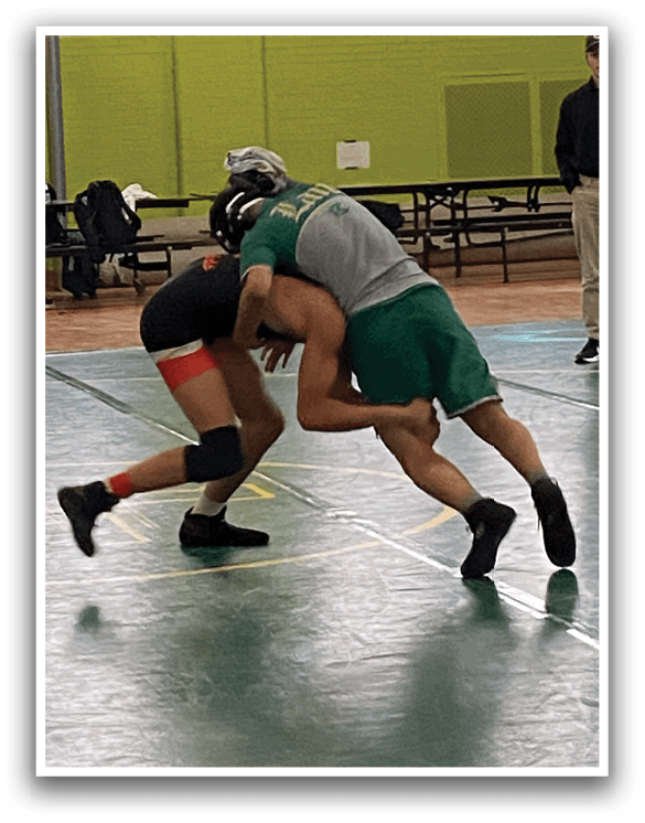 Two men are wrestling on a green court. One man is on top of the other, both wearing black shorts. AI generated content