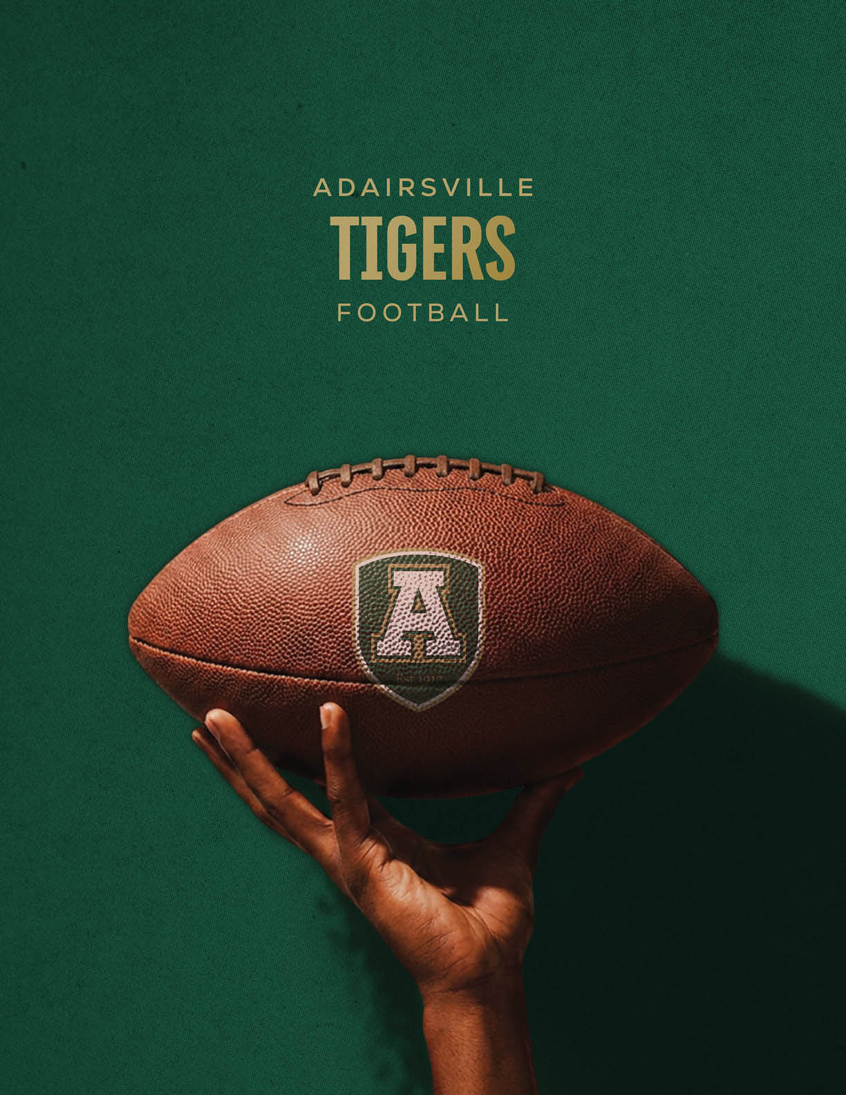A hand is holding a football with an “A" logo on it against a dark green background with the text "Adairsville Tigers Football" above. Description generated by AI