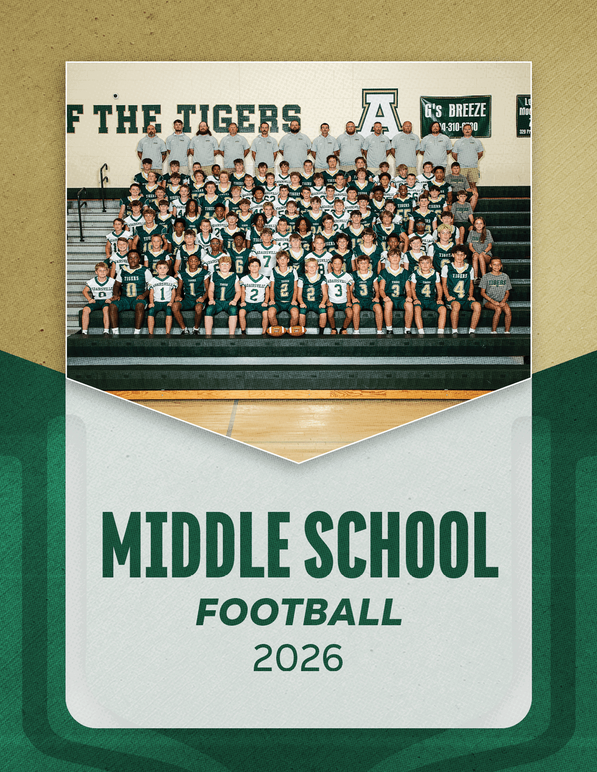 A large group of children in football uniforms and adults in matching shirts pose for a team photo on bleachers inside a gymnasium with a banner reading Middle School Football 2026. Description generated by AI