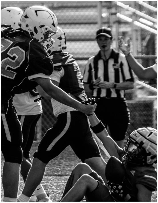 A group of football players wearing black and white uniforms. Description generated by AI