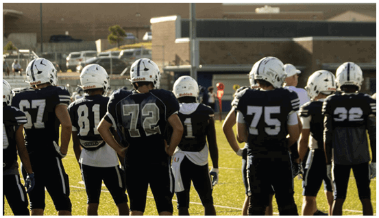 A group of football players on a field. Description generated by AI