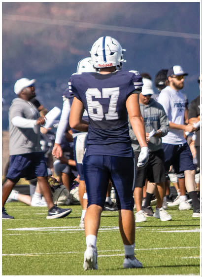 A football player wearing a blue jersey with the number 58 on it. Description generated by AI