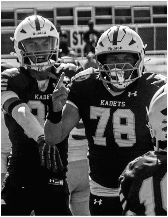 A group of football players wearing black and white uniforms. Description generated by AI
