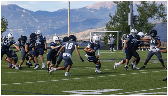 A group of football players on a field. Description generated by AI