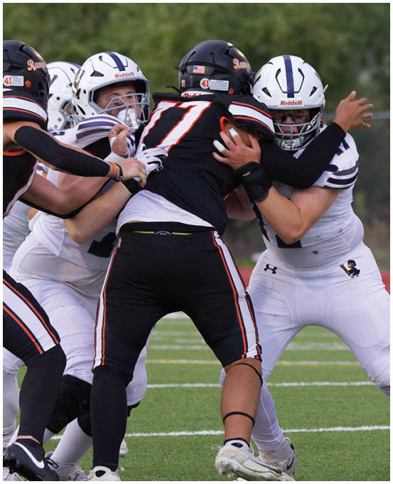 A group of football players wearing black and white uniforms. Description generated by AI