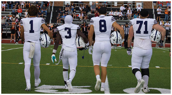 A group of football players on a field. Description generated by AI