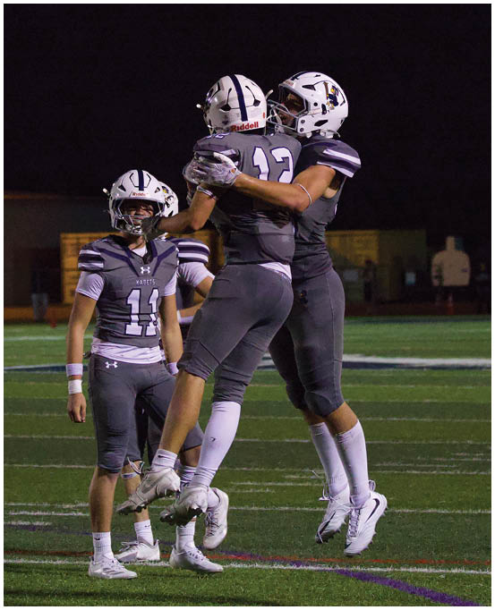 A group of football players wearing black and white uniforms. Description generated by AI