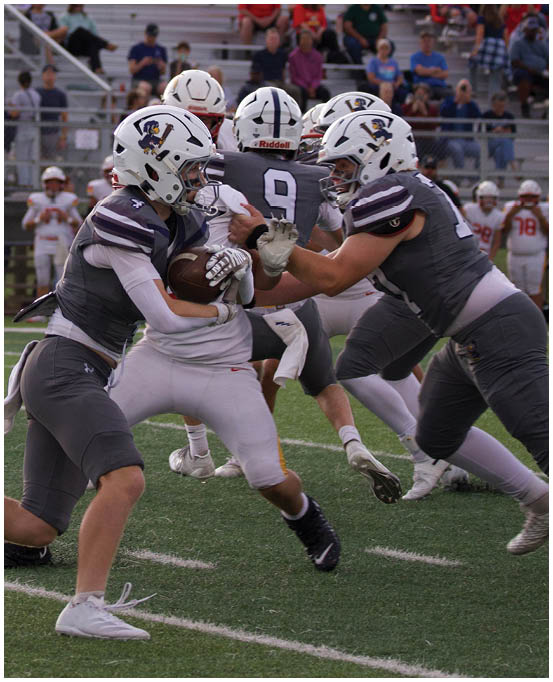 A group of football players wearing black and white uniforms. Description generated by AI