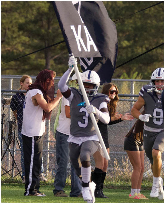 A group of football players wearing black and white uniforms. Description generated by AI