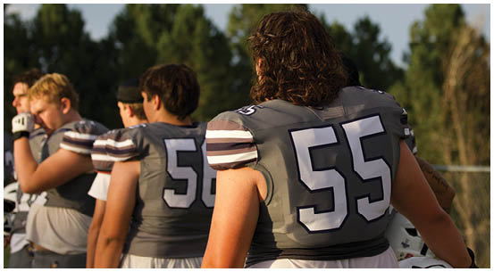 A group of football players on a field. Description generated by AI