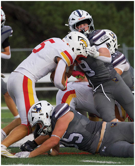 A group of football players wearing black and white uniforms. Description generated by AI